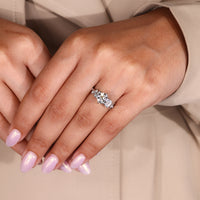 Emerald and round cut side stones engagement ring.