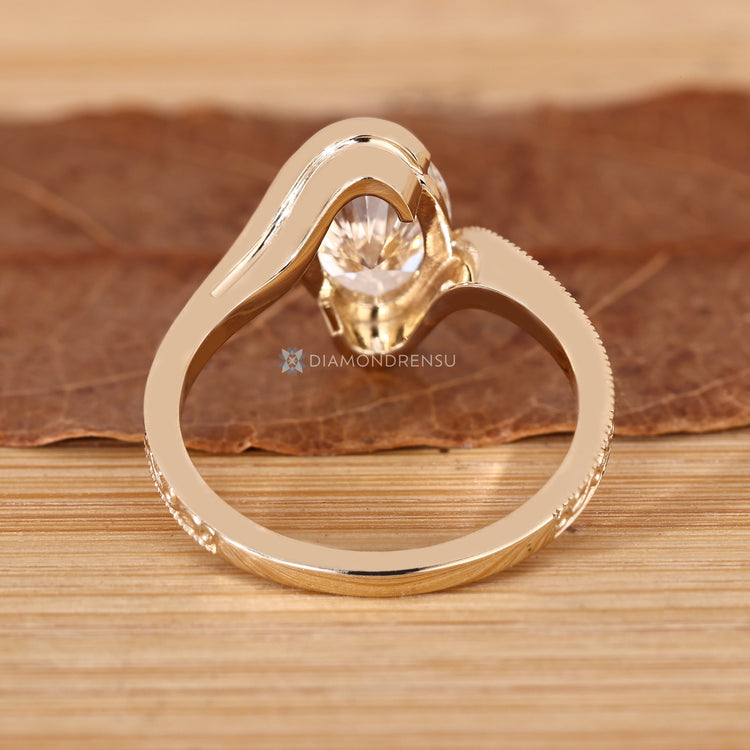 Oval diamond solitaire ring with milgrain accents.