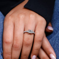 Pear side stone in princess cut diamond engagement ring.
