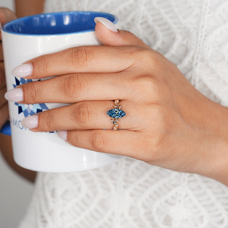 Blue marquise diamond ring with leaf style prongs.