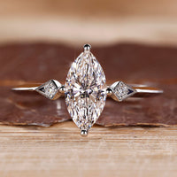 Marquise diamond ring round side stones three stone.