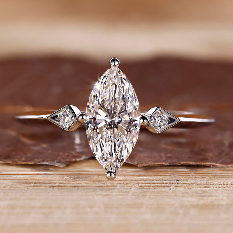 Marquise diamond ring round side stones three stone.