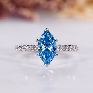 Marquise diamond engagement ring with blue sapphire accent.