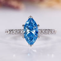 Marquise diamond engagement ring with blue sapphire accent.