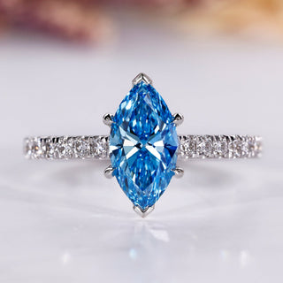 Marquise diamond engagement ring with blue sapphire accent.