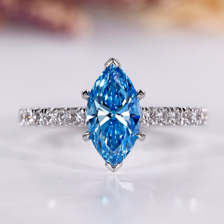 Marquise diamond engagement ring with blue sapphire accent.