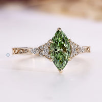 Green marquise diamond ring with tapered shank.