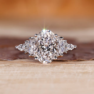 Oval diamond ring with marquise and round side stones.