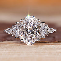 Oval diamond ring with marquise and round side stones.