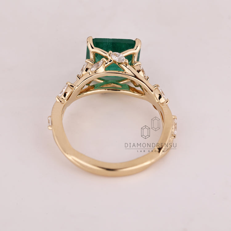 Asscher cut ring emerald cluster four claw prong set.