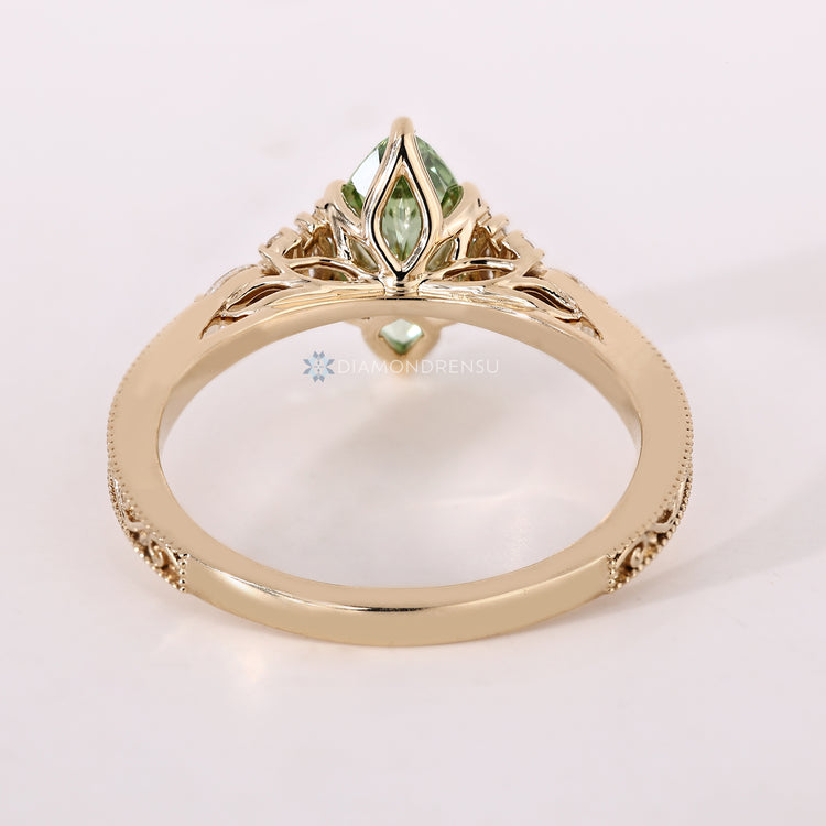 Green diamond ring with marquise side stones.