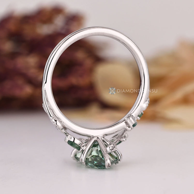 Handmade engagement ring featuring green diamond and moss agate accents.