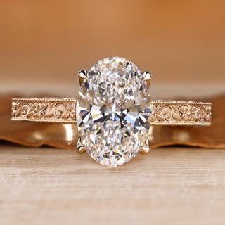 Oval cut diamond ring with round bridge accents.