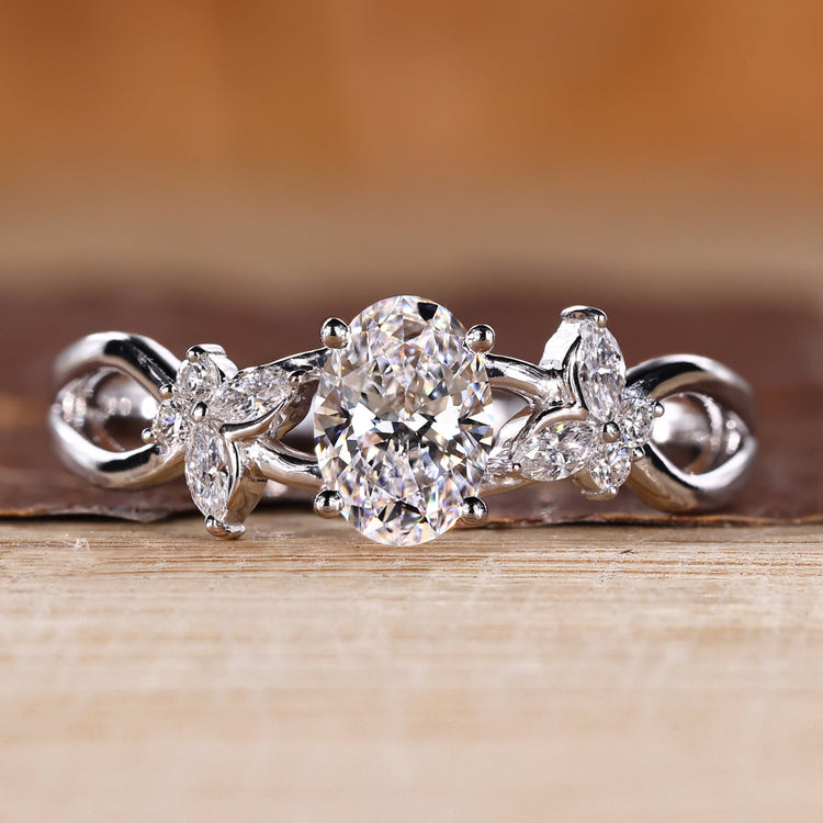 Oval diamond engagement ring with marquise and round side stones.