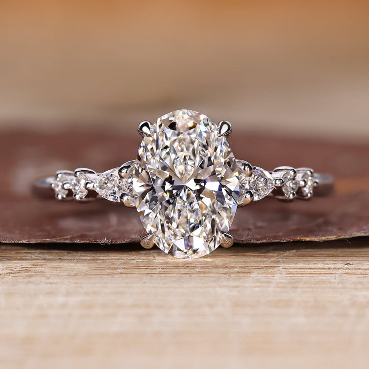Oval diamond ring pear round side stones cathedral.