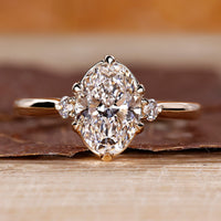 Oval cut diamond ring round side stones three stone.