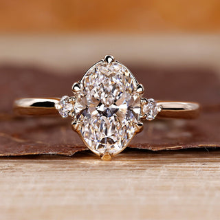 Oval cut diamond ring round side stones three stone.