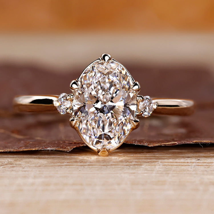 Oval cut diamond ring round side stones three stone.