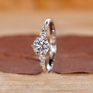 Round engagement ring with five diamonds in tapered shank design.
