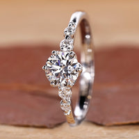 Round engagement ring with five diamonds in tapered shank design.