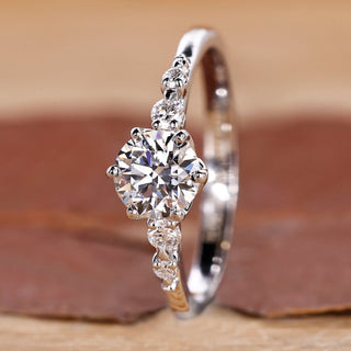 Round engagement ring with five diamonds in tapered shank design.