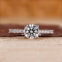 Pave engagement ring with round diamond center.