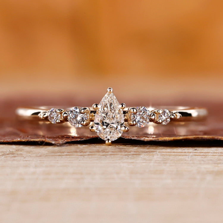 Pear diamond engagement ring with a 5 stone ring.