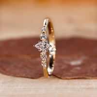 Pear diamond engagement ring and round side stone match well.