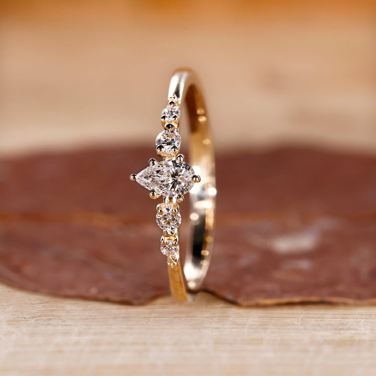 Pear diamond engagement ring and round side stone match well.