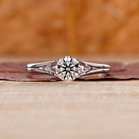 Split shank engagement ring with round cut diamond centre.