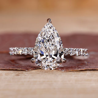 Pear shaped diamond ring with pave setting in white gold.