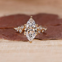 Cluster diamond ring with marquise cut center stone in yellow gold.