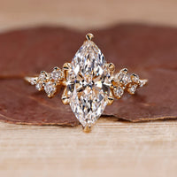 Cluster diamond ring with marquise cut center stone in yellow gold.