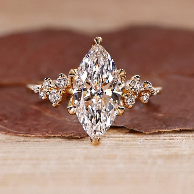 Cluster diamond ring with marquise cut center stone in yellow gold.