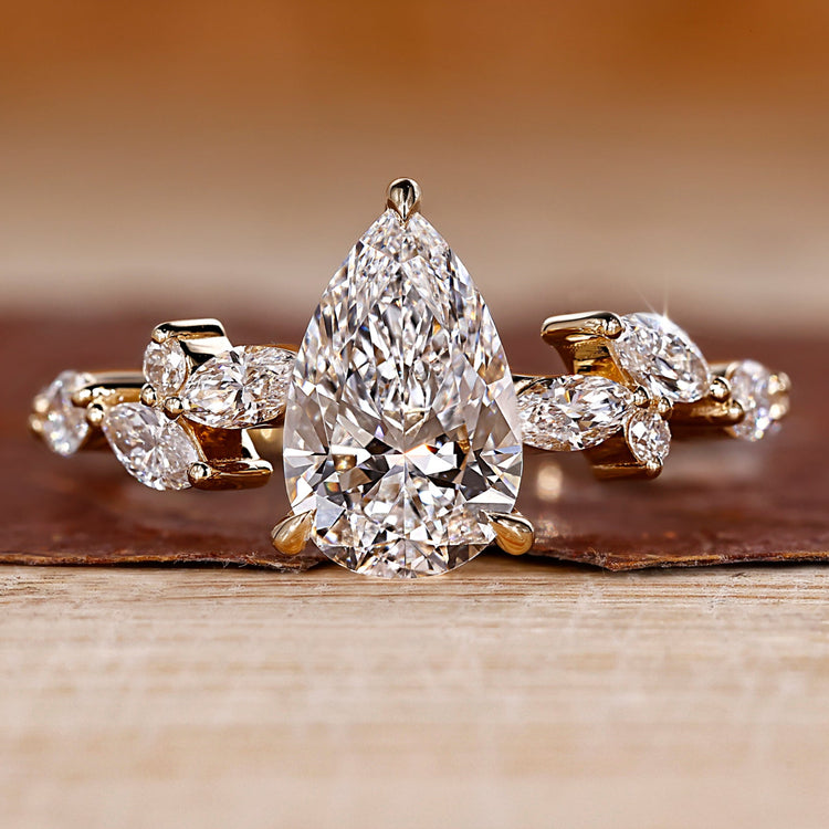 Pear diamond engagement ring with cluster engagement ring.