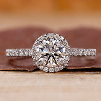 Pave diamond ring with round cut center stone.