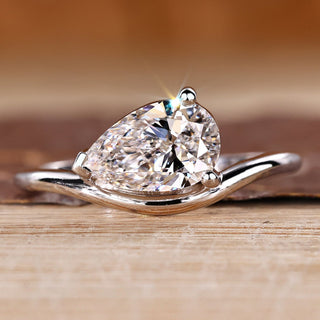 Pear diamond ring in solitaire style with east to west setting.