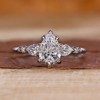 Pear cut diamond ring pear round side stones seven stone.