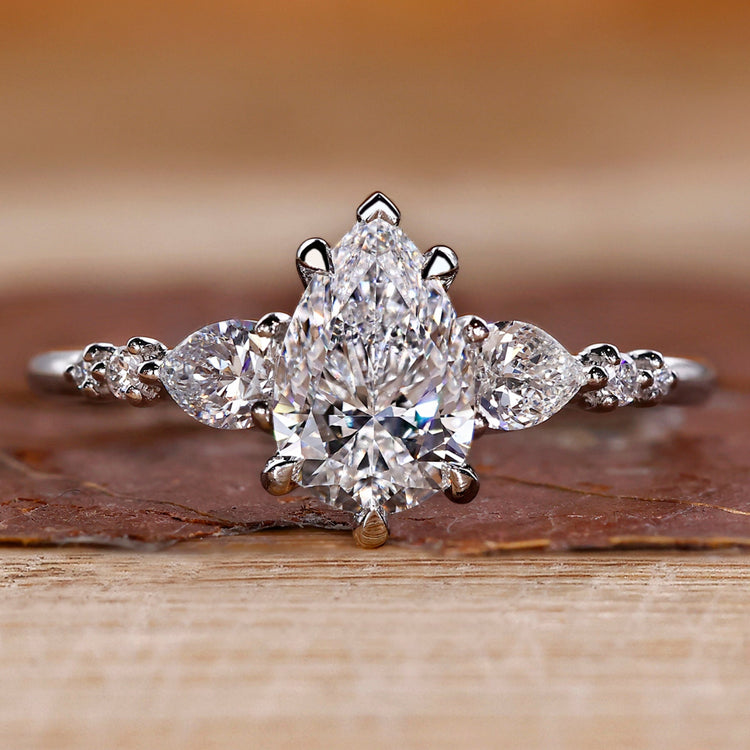 Pear cut diamond ring pear round side stones seven stone.