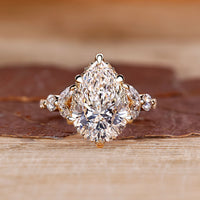 Pear cut diamond engagement ring with round and marquise side stones.