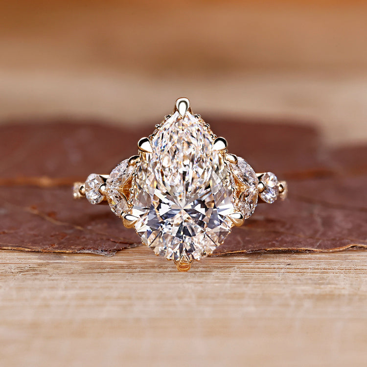 Pear cut diamond engagement ring with round and marquise side stones.
