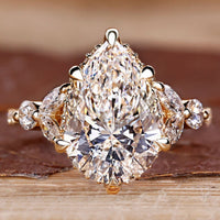 Pear cut diamond engagement ring with round and marquise side stones.