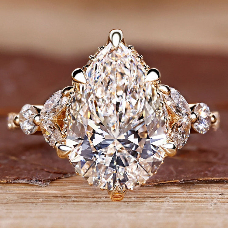 Pear cut diamond engagement ring with round and marquise side stones.