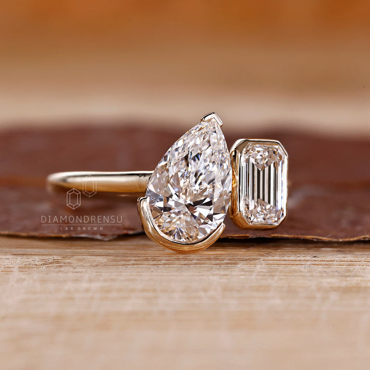 Pear emerald diamond ring two stone prong setting.