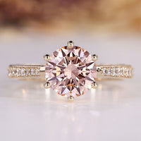 Round diamond ring with pink diamond accent.