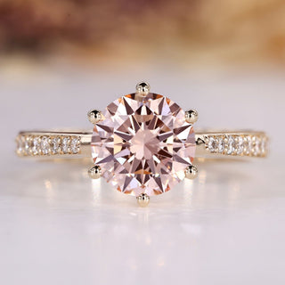 Round diamond ring with pink diamond accent.