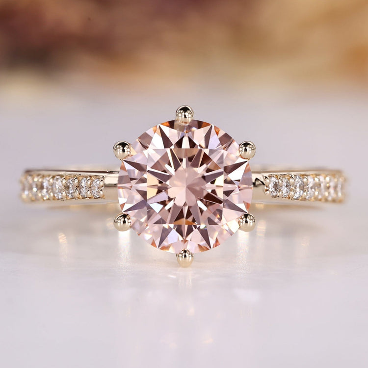 Round diamond ring with pink diamond accent.
