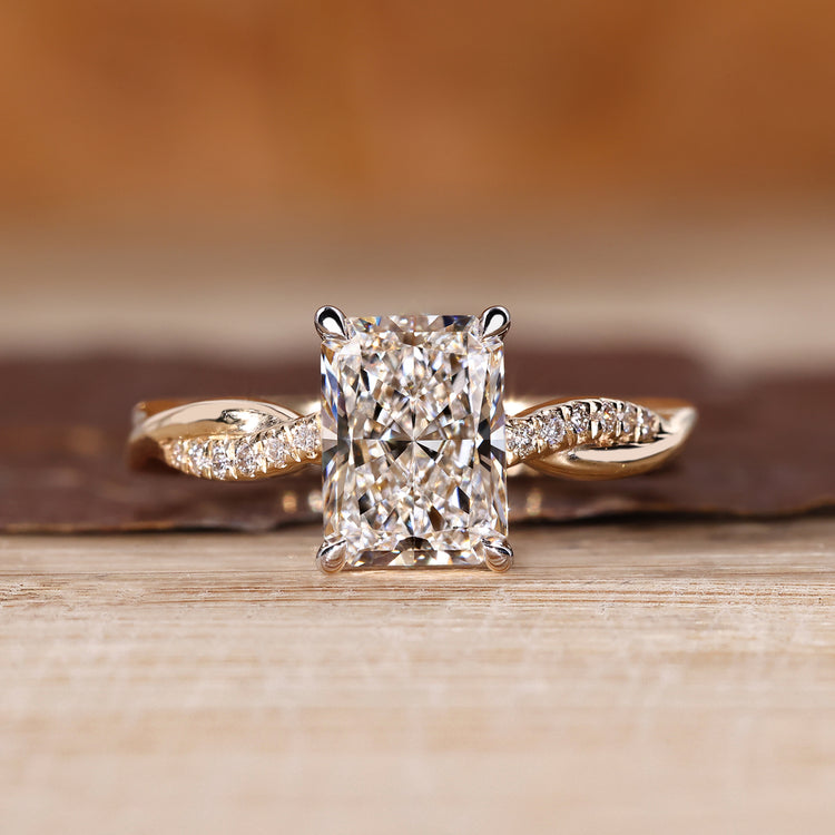 Radiant cut diamond ring with round diamond pave band.