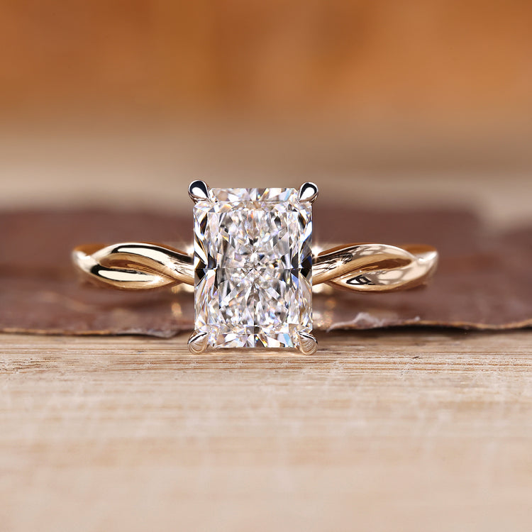 Radiant cut diamond ring with twisted shank in solitaire style.