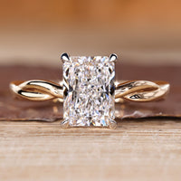 Radiant cut diamond ring with twisted shank in solitaire style.